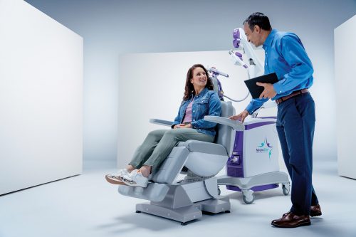 Image of patient sitting in a NeuroStar chair talking to a physician